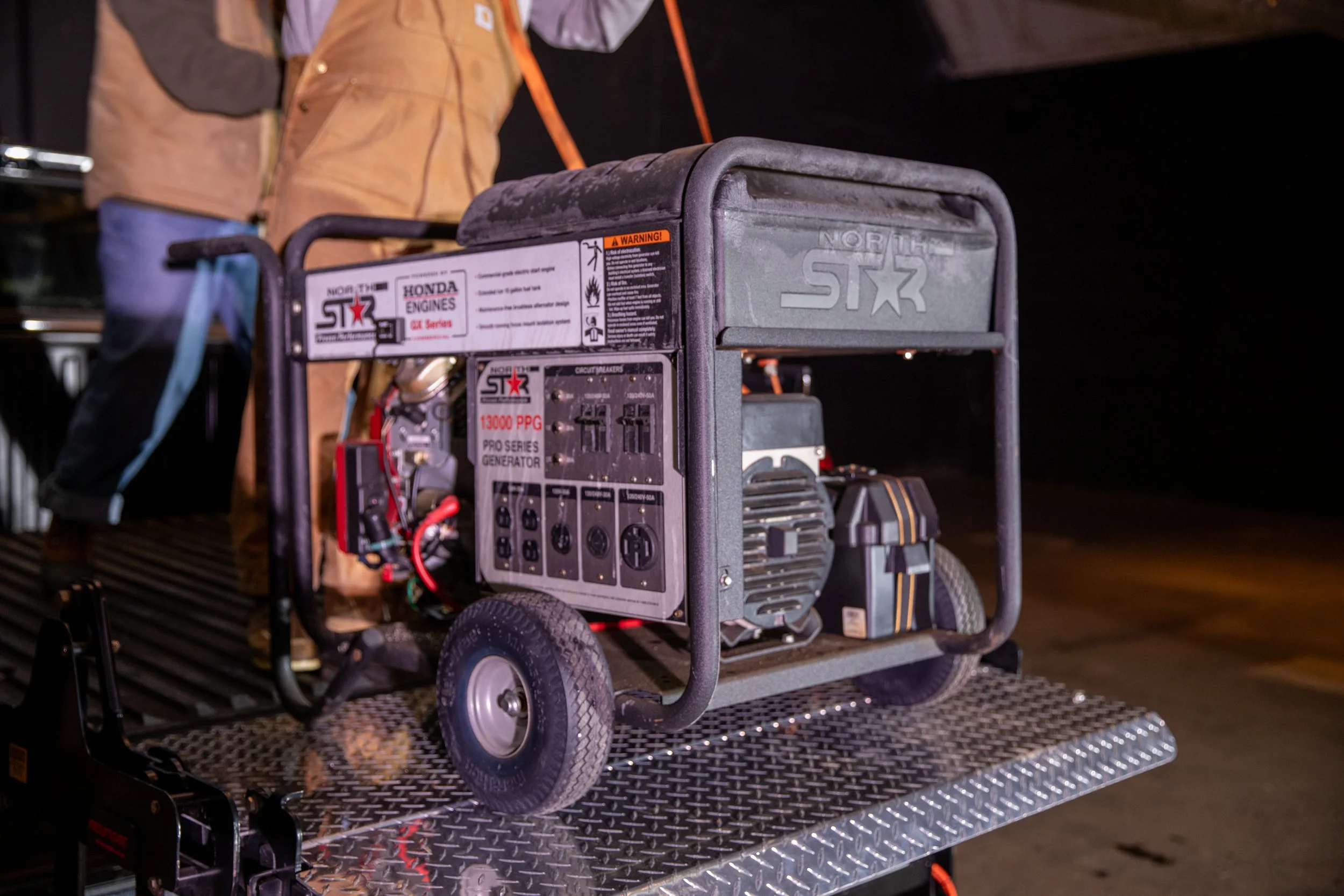 A portable Honda generator on the ProLiftgate, with people standing in the background.