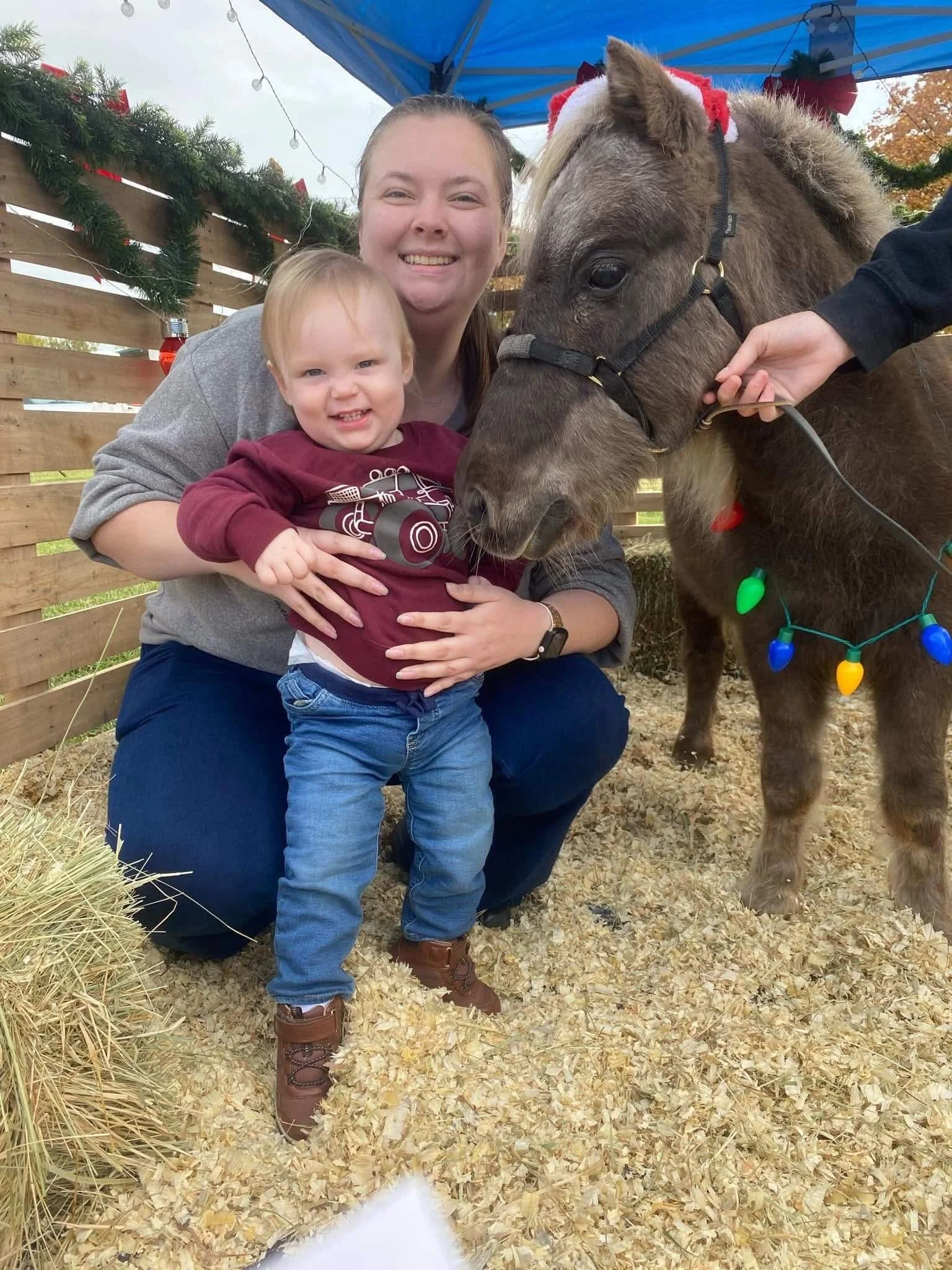 Photo of Staff Member Kaitlin posing with her son and smiling warmly.