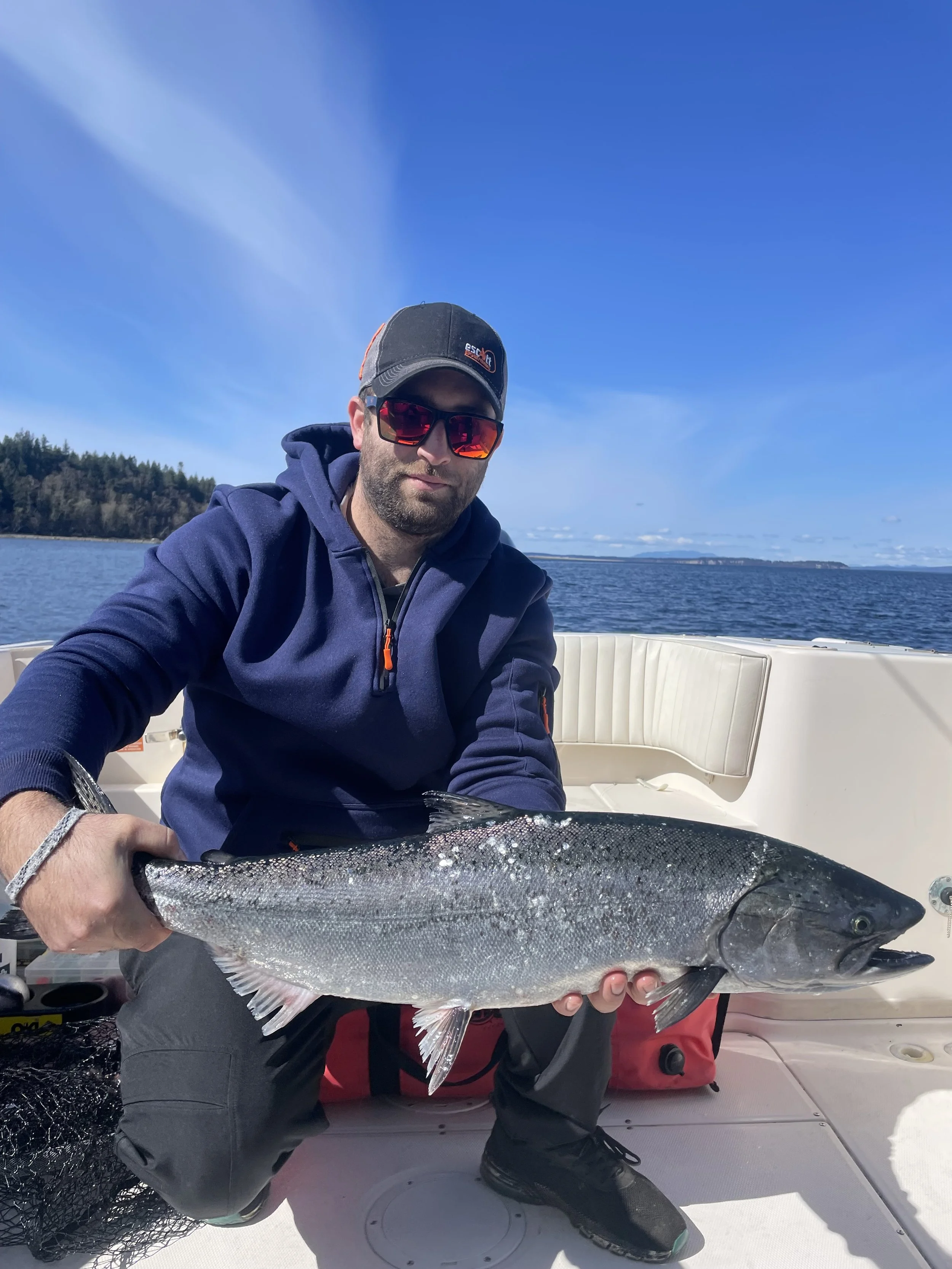 Guest holding a chinook salmon on a calm sunny day