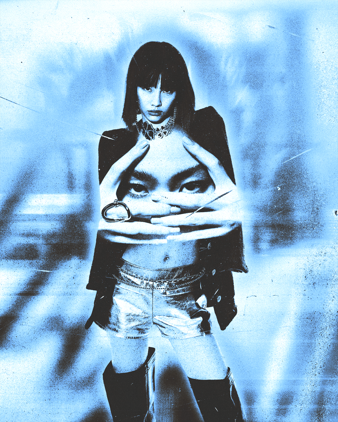 A stylized, monochrome blue-tinted image of a woman with dark hair and bangs, wearing a black jacket, denim shorts, and tall boots. Her face is shown on a large hand and face in front of her, with her hands framing her head and gaze directed forward.