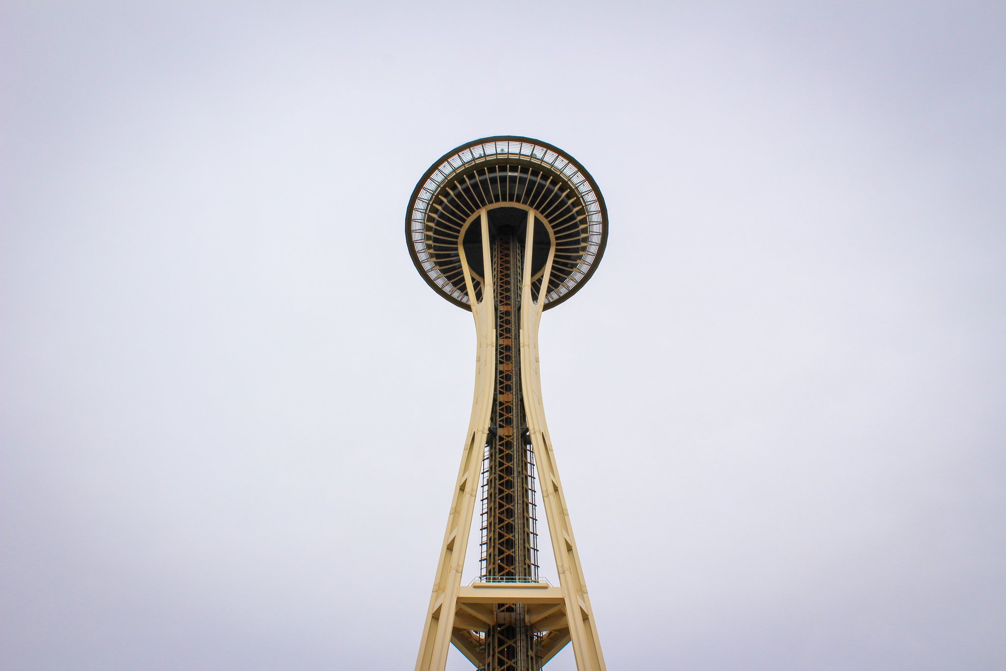 The Space Needle, a tall observation tower with a circular top and a narrow base, against an overcast sky.