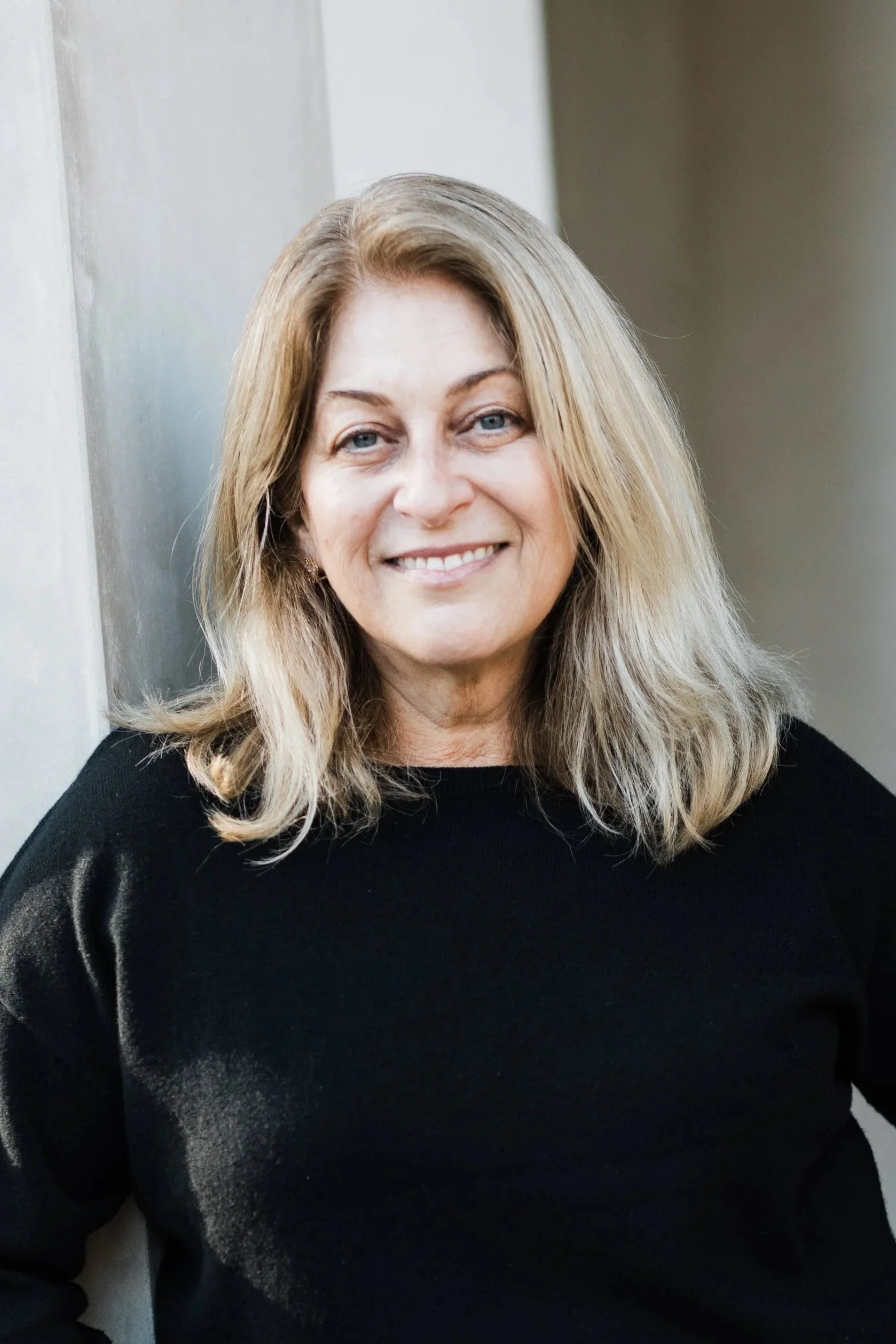 Portrait of person with shoulder length hair wearing a dark sweater