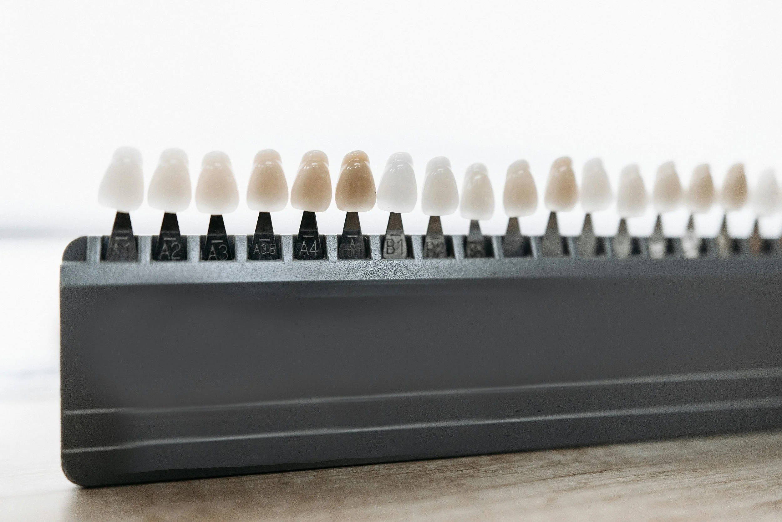 A shade guide with various shades of teeth, labeled from A2 to B7, used in dentistry to match tooth colors.