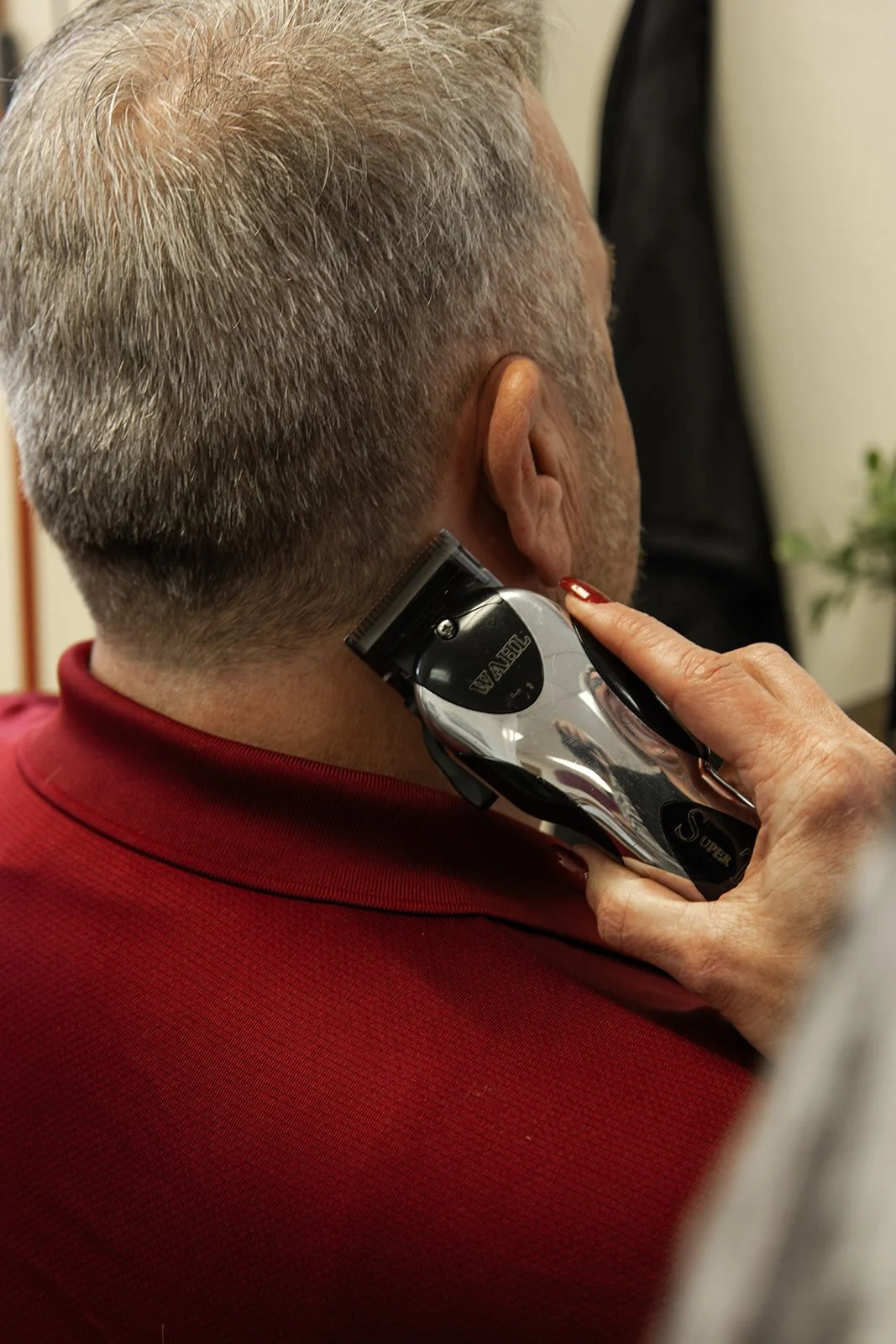 Scenic landscape of a large lake surrounded by rolling hills and mountain range with overcast sky.