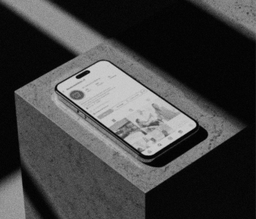 A smartphone resting on a concrete surface displaying a social media profile and photos.