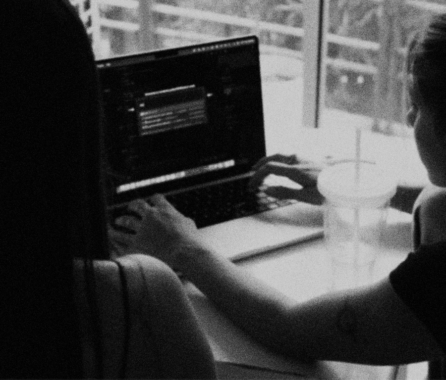 Lava's two founders entering a client meeting on a laptop computer at a table, with a window and a drink in the background.