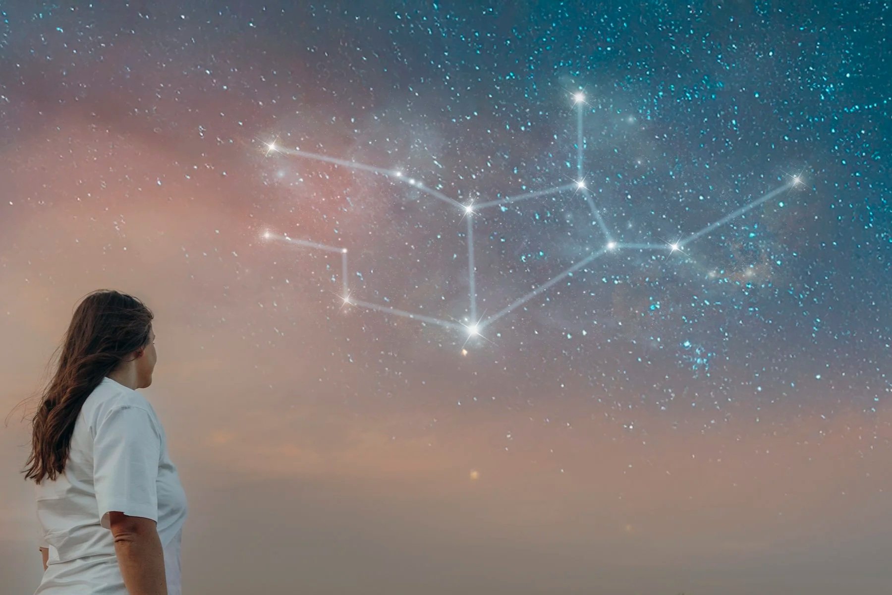 A woman with windswept brown hair gazes at the sky. The constellation Virgo is visible through the clouds.