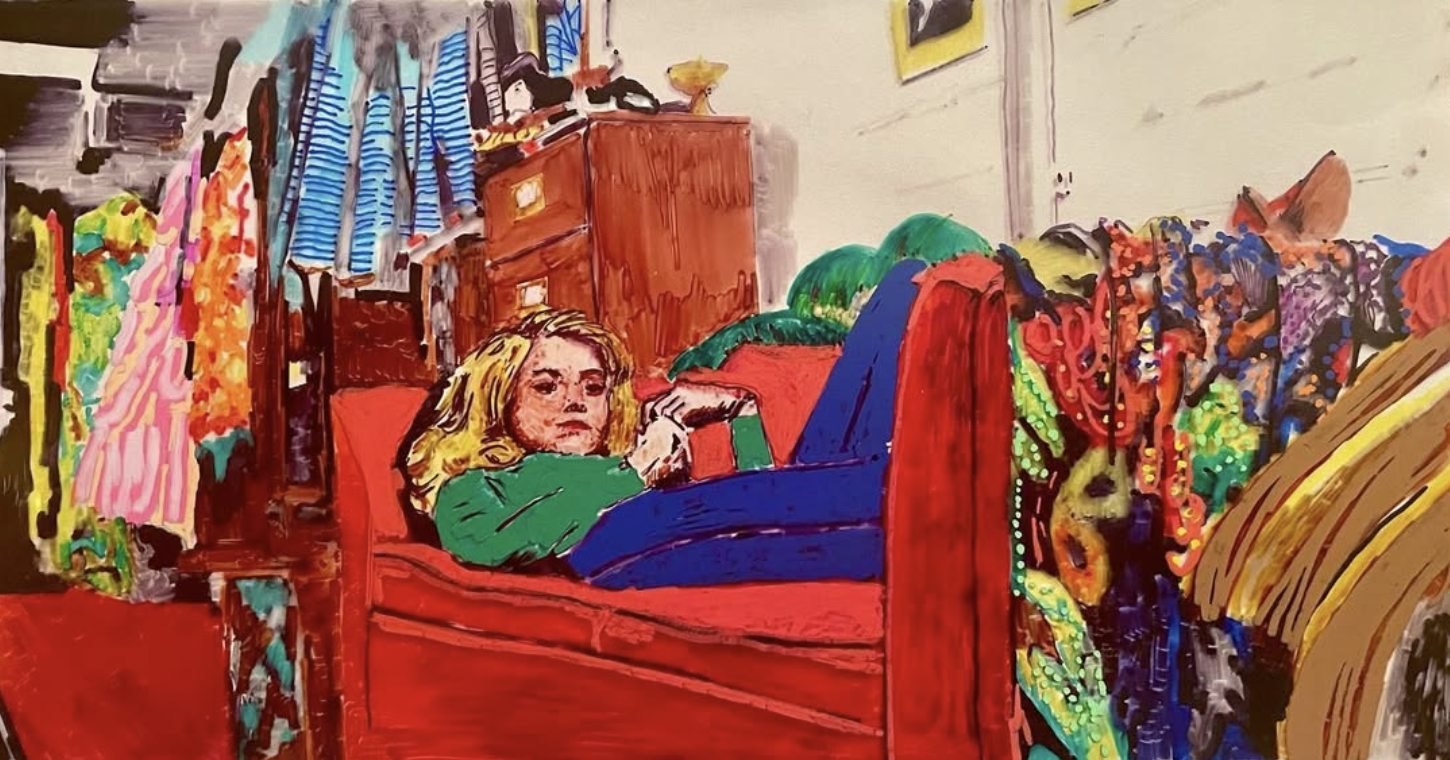 A woman with blonde hair lying on a red bed, surrounded by colorful clothes and furniture. The room has a dresser, hanging clothes, and a wall with yellow picture frames.