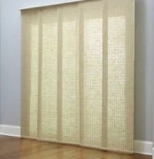 A beige vertical blind covering a window in a room with light grey walls and a wooden floor.
