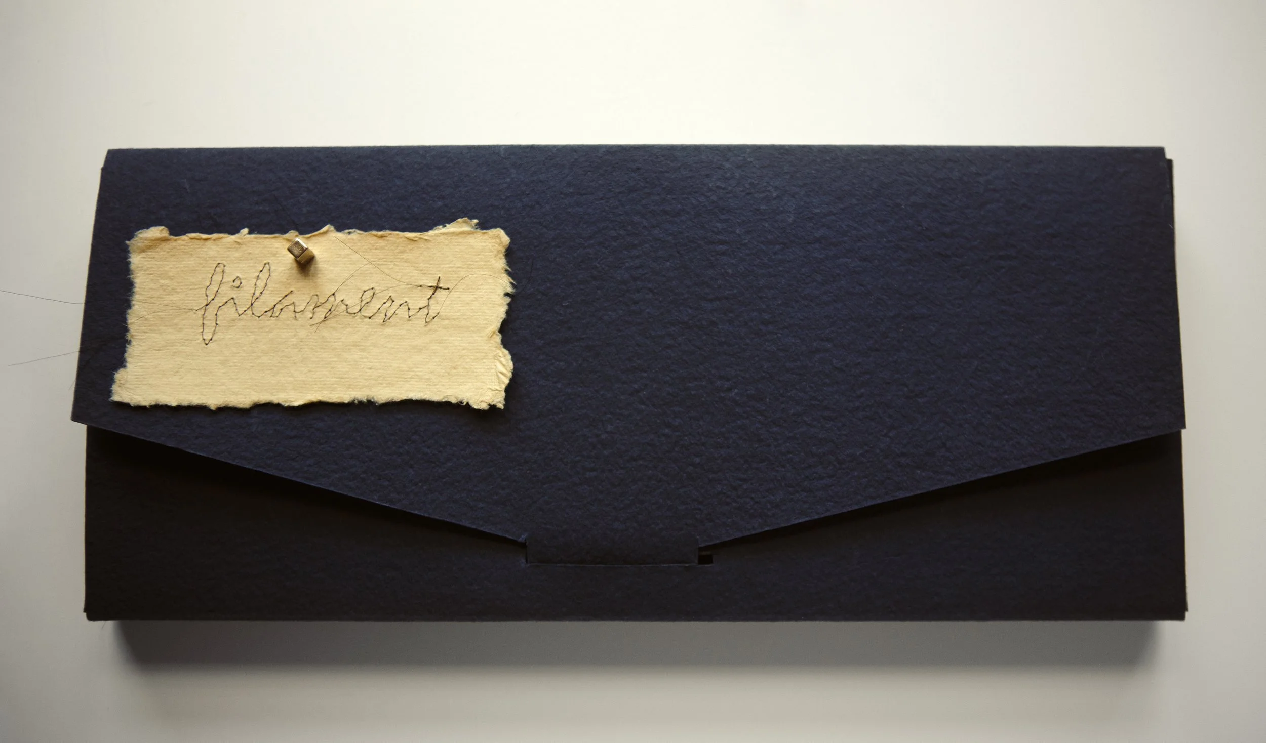 Filament - Closed black folio with the title ‘filament’ on the upper left corner