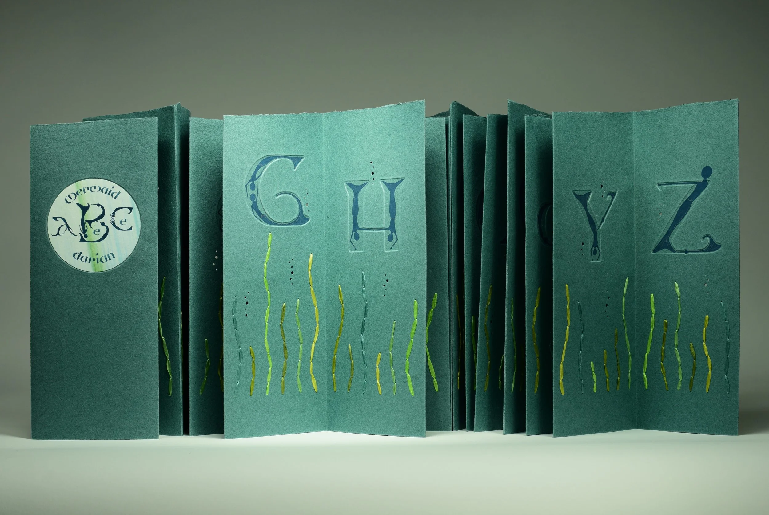 Mermaid ABeCeDarian – Embossed letters designed to draw the mermaid bestiary within.