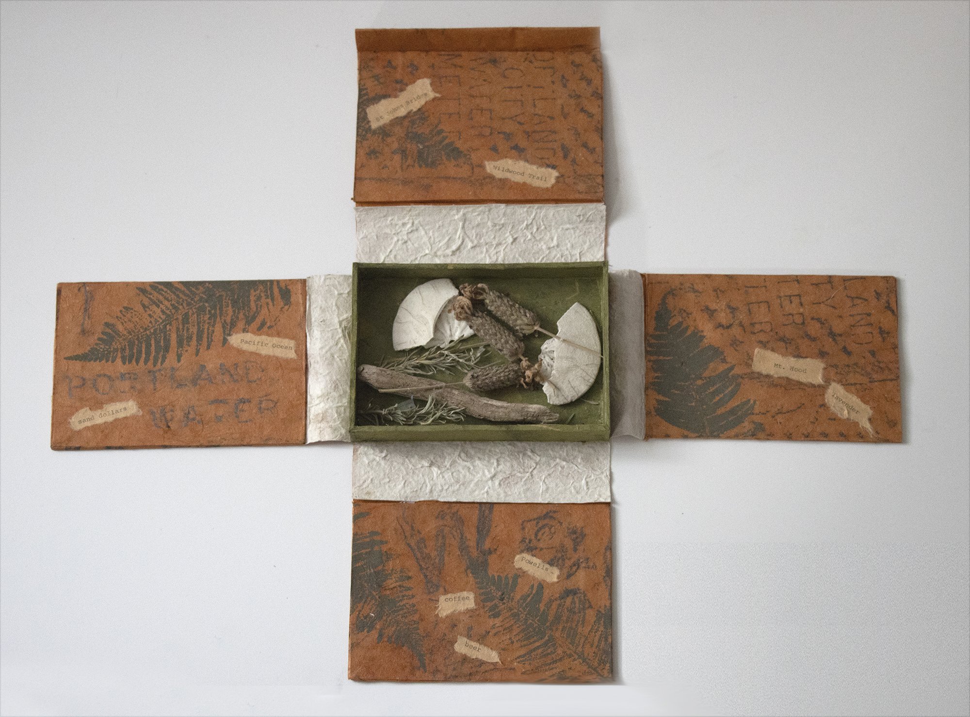 This box book was done at a workshop at the Sitka Center on the coast of Oregon. The black accents are rubbings from Portland streets. The middle container holds lavender from my garden and shells and driftwood from near Sitka. 