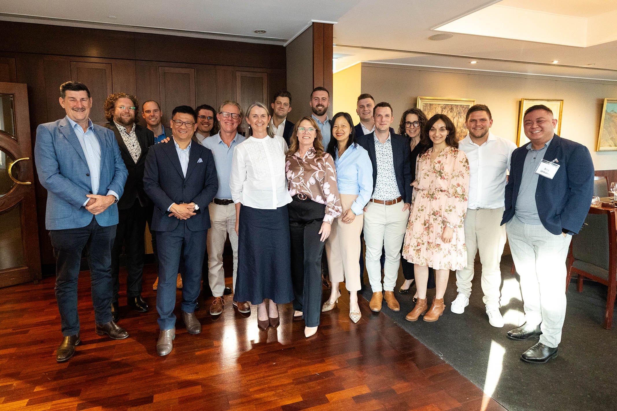 Group of diverse professionals smiling and posing for a photo in a conference room.