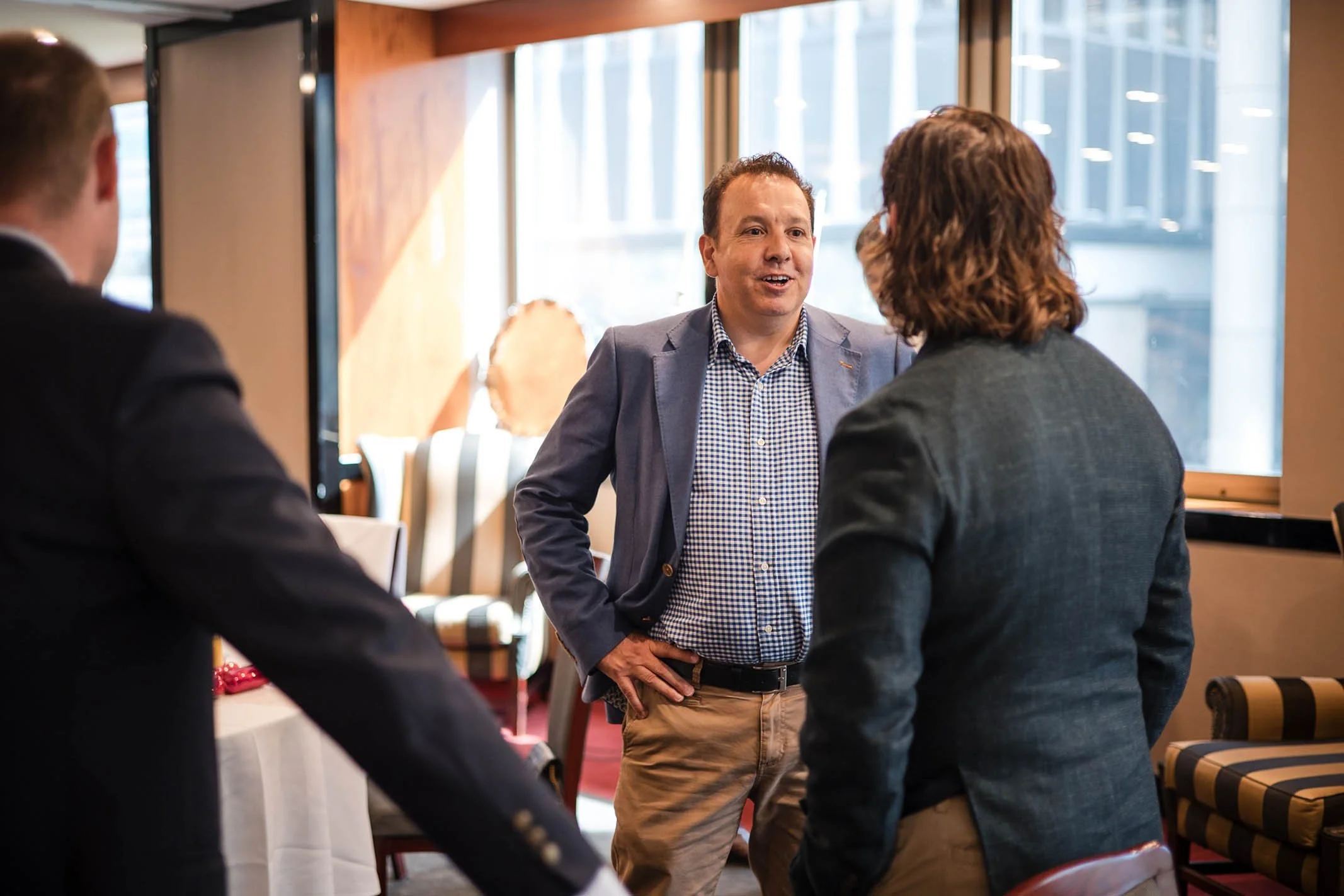 Three people having a conversation in a restaurant or cafe.