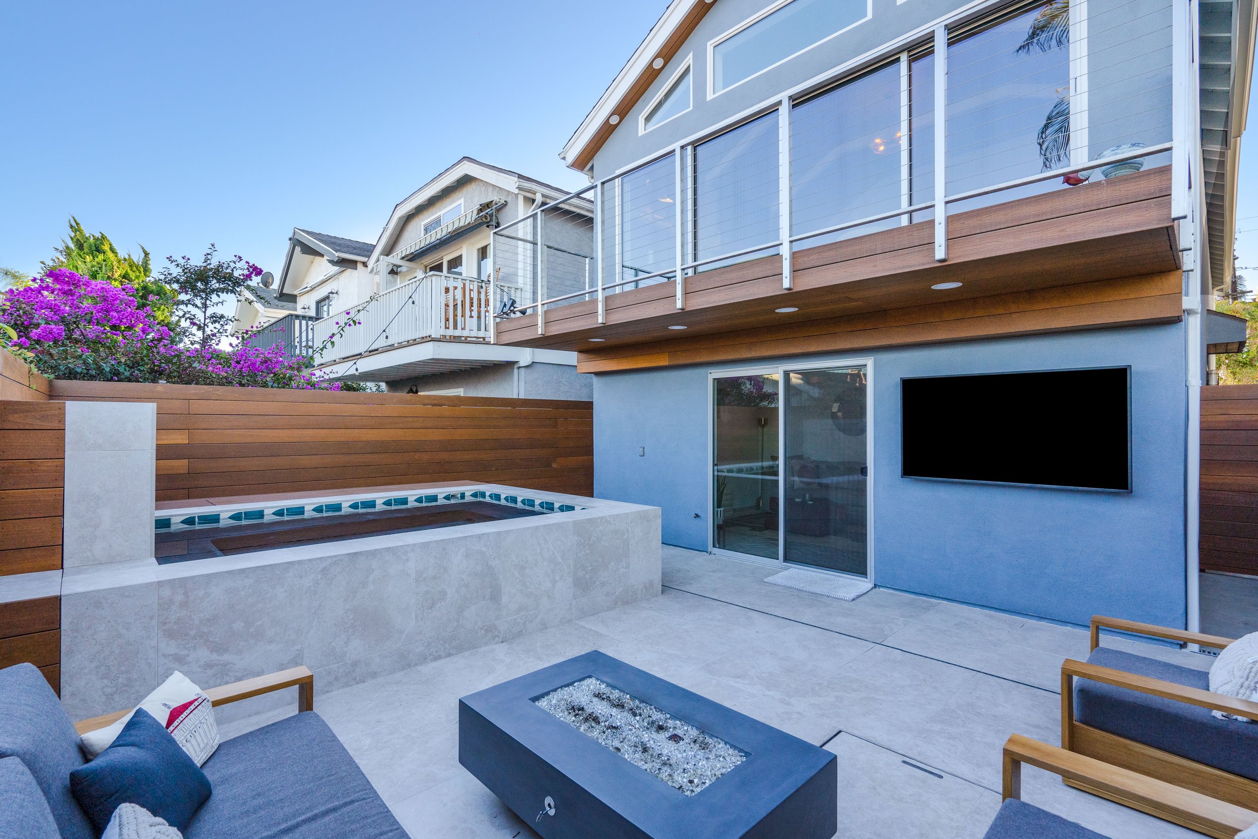 Luxury outdoor patio remodel with elevated deck, modern railing system, lounge seating, and contemporary exterior finishes.