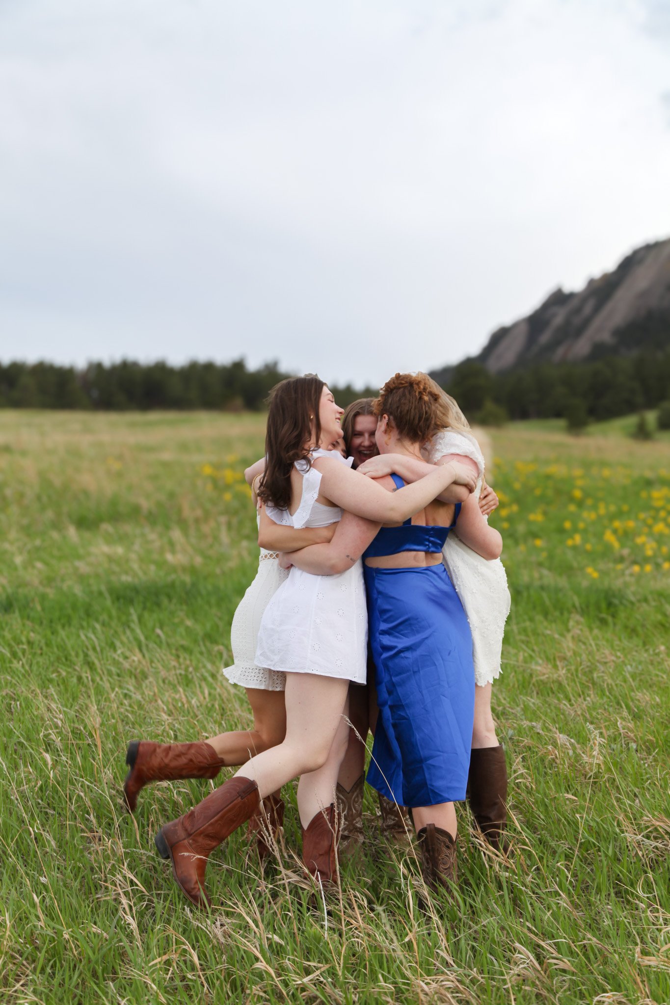 Group of women in a field hugging and smiling.