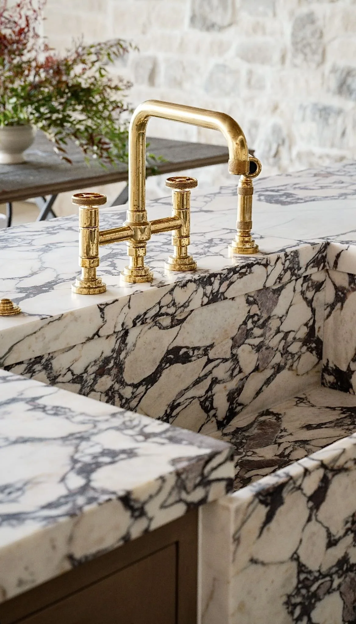 bold marble benchtop with weathered brass tapware