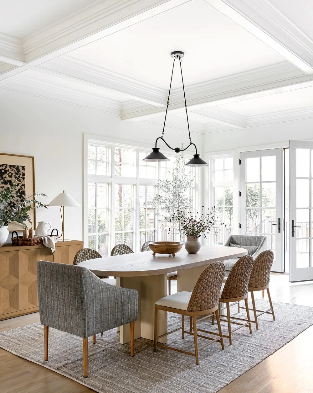 warm and inviting dining room with white coffered ceilings above
