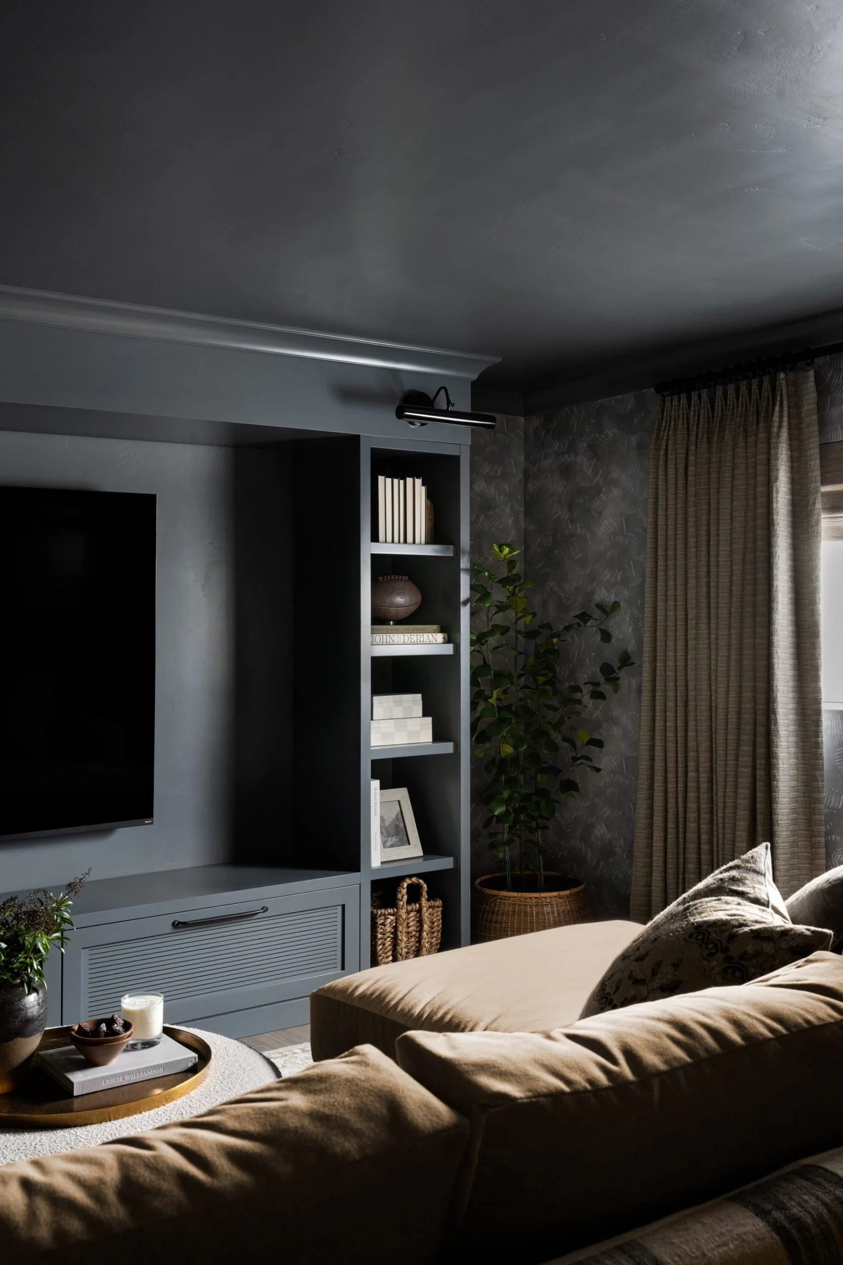 Moody, colour drenched theatre room with large tan fabric sectional lounge