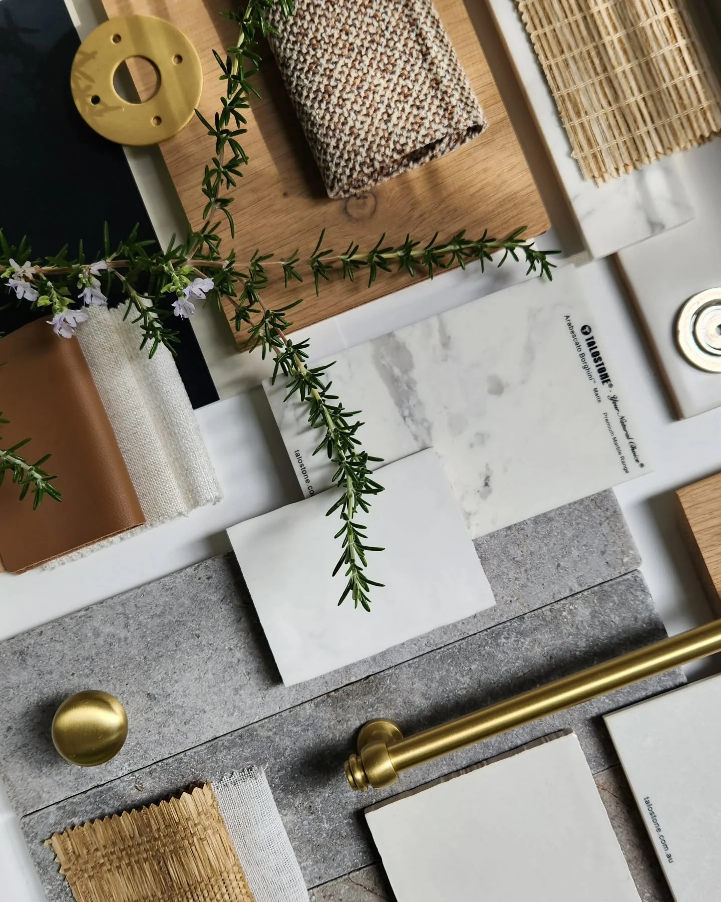 A flat lay by Oak & Olive Homes of various sample materials laid out, showcasing tiles, stone, metals, textiles, handles and other project finishes