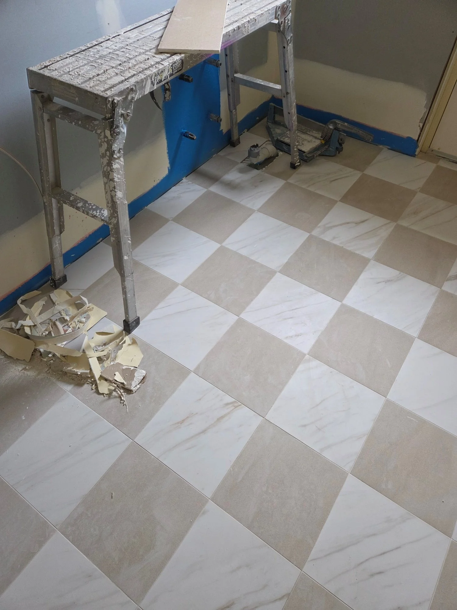 checkerboard tiles being laid in a renovated laundry at our Bowral project