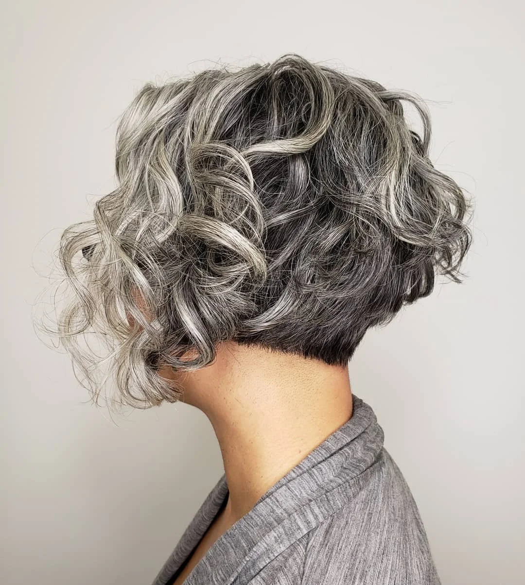 Short hairstyle with curly, silver and black hair. Haircut by Tiffany Shuck of Rooted Ritual Salon, formerly Hare Salon.