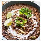 Bowl of salsa with lime wedges, cilantro, and sliced green chili peppers