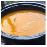 Close-up of a bowl filled with orange-colored soup.