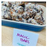 Close-up of a container of magic bars with a handwritten sign in front that says 'MAGIC BARS'.