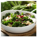Salad with greens, berries, and cheese in a white bowl