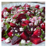 A colorful beet and cucumber salad topped with feta cheese.