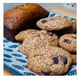 Assortment of cookies and a loaf of bread on a blue patterned cloth