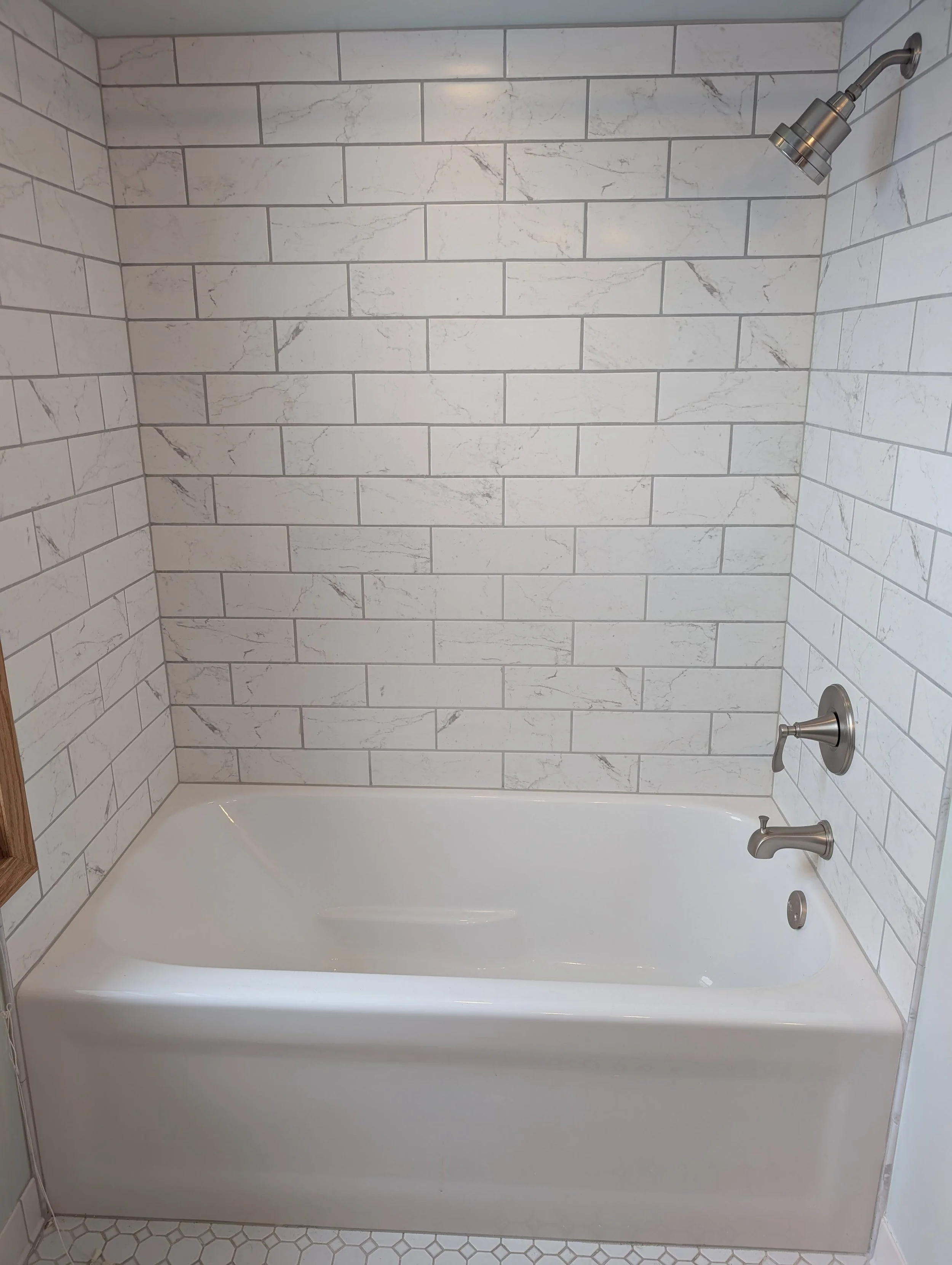 Tub shower alcove remodel with white porcelain marble tile