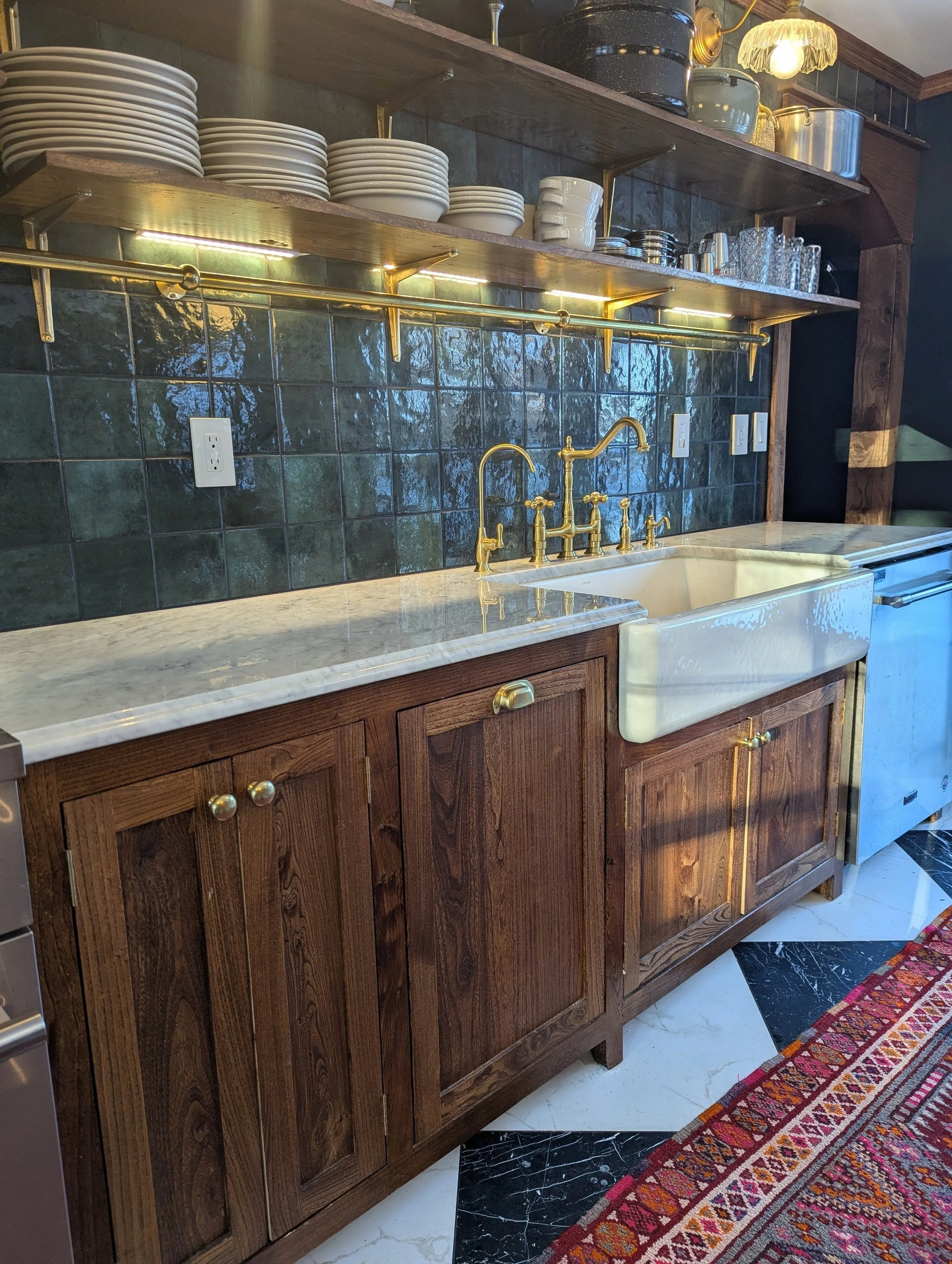 Custom wood kitchen cabinets with farmhouse sink and brass faucet in kitchen remodel.