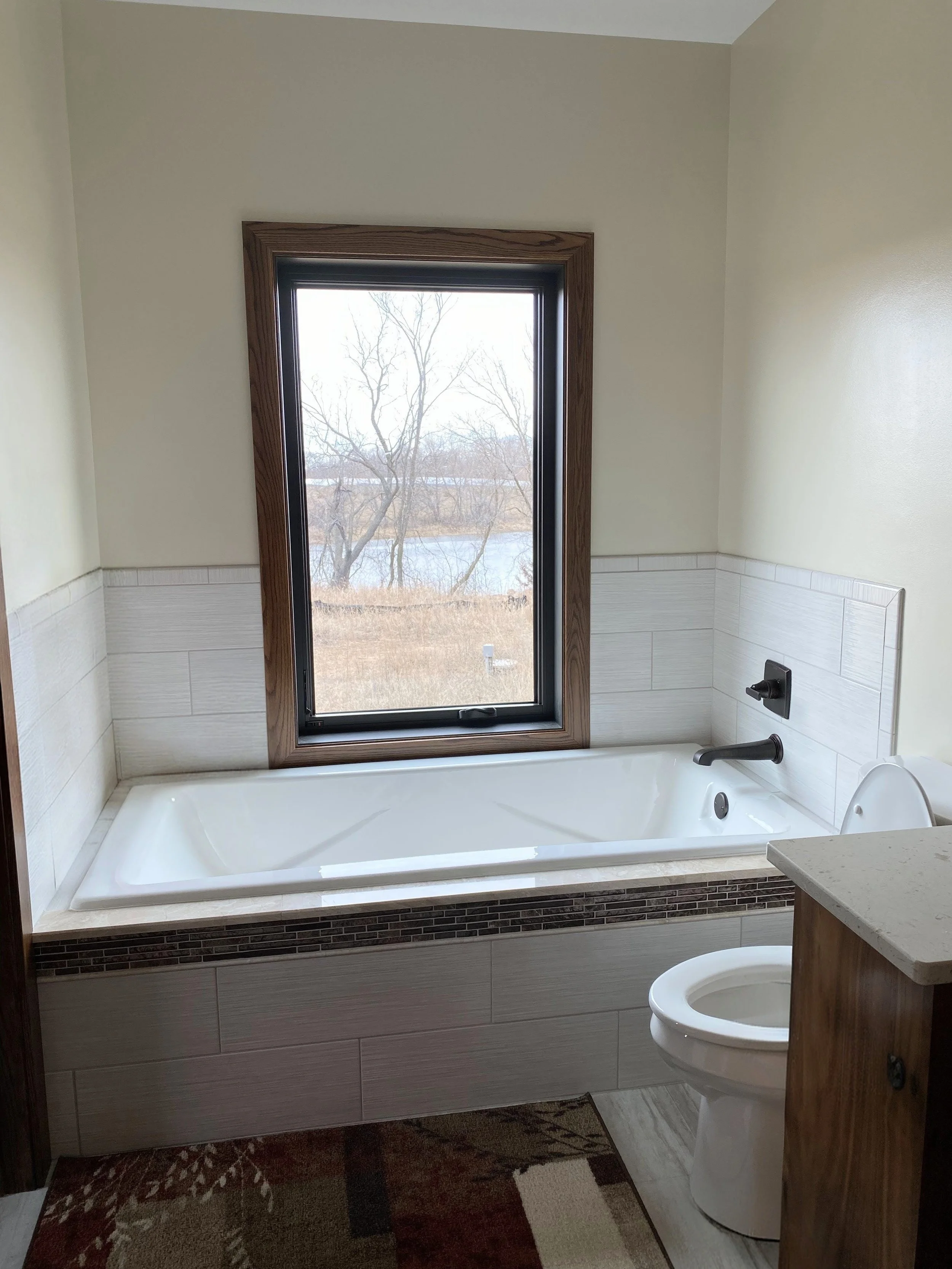 Alcove tub with window above and wall tile in Scandia MN home