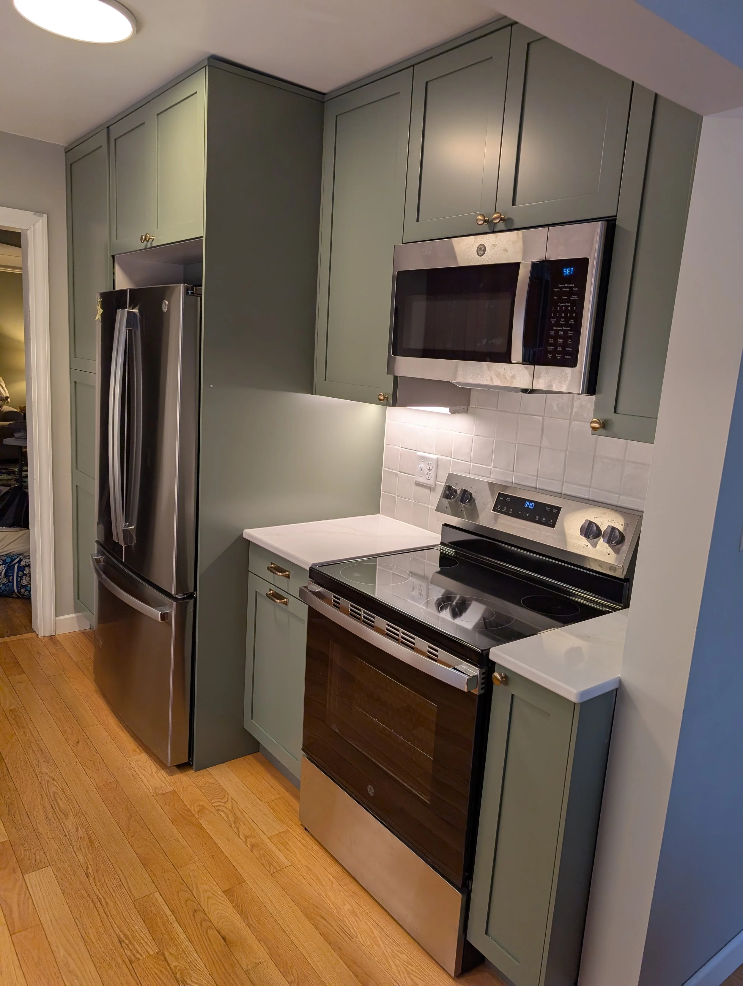 Sage green Klearvue cabinetry with white quartz countertops in Kitchen remodel