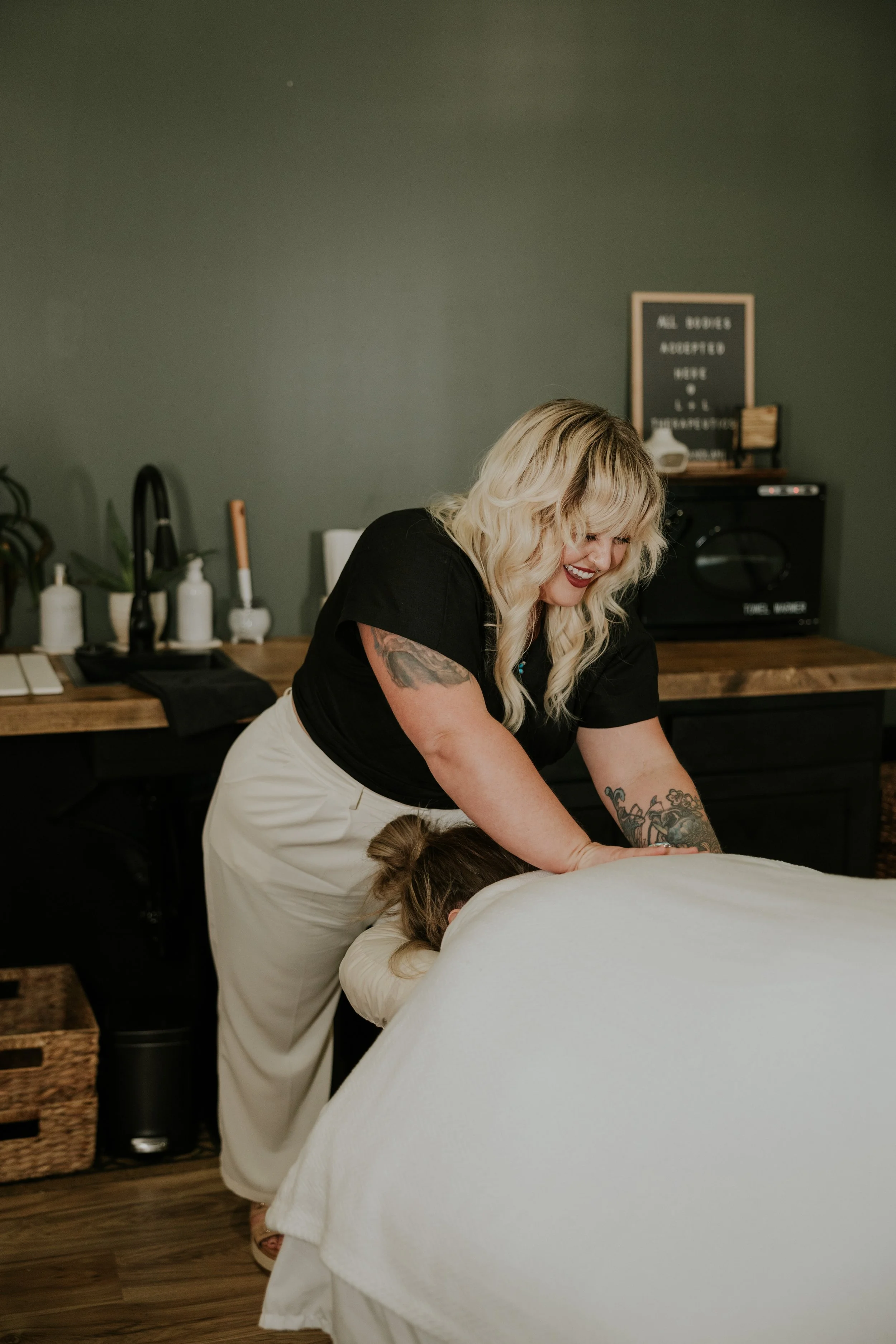 Massage therapy session at Linc + Lani in Knoxville, Tennessee, with practitioner providing hands-on bodywork to a client.
