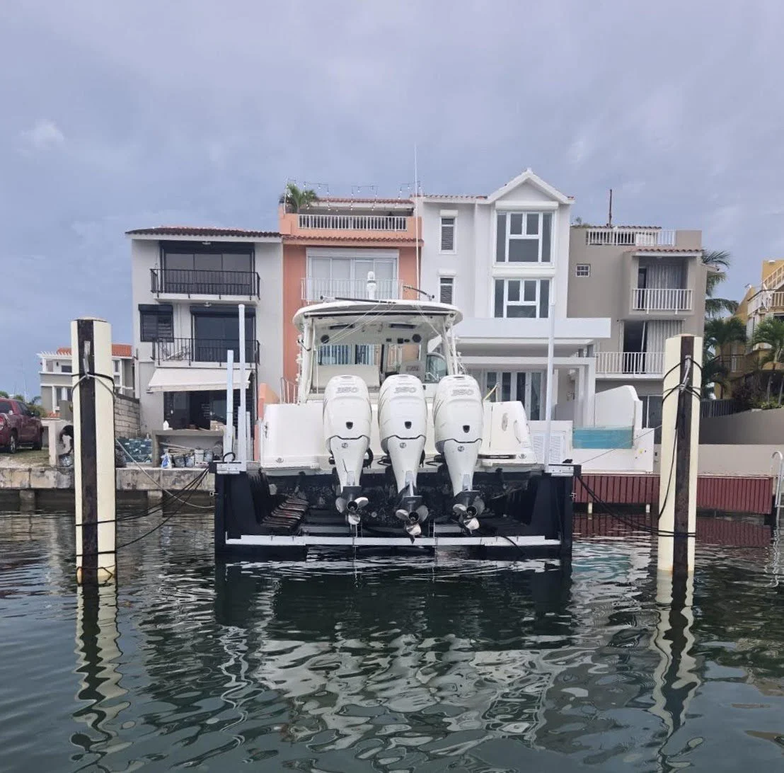 Motorboat docked at a marina with multi-story residential buildings in the background.