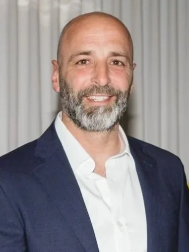 An orange pen with a black cap positioned vertically on the right side of a plain white background.