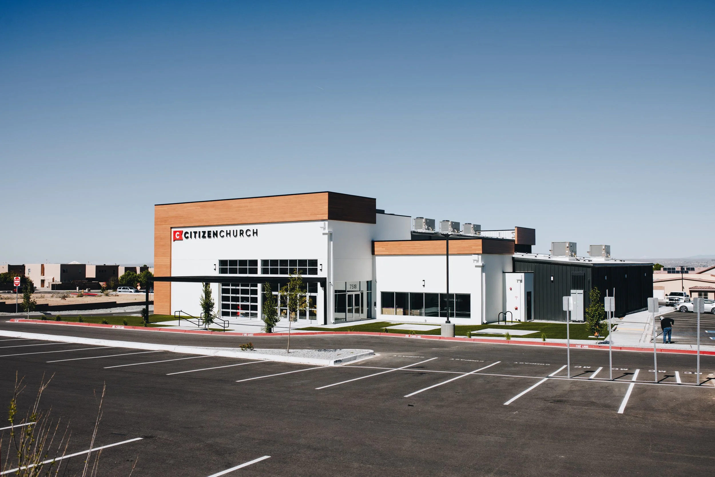 Empty parking lot in front of a modern church building with the sign 'Citizen Church' on the front.