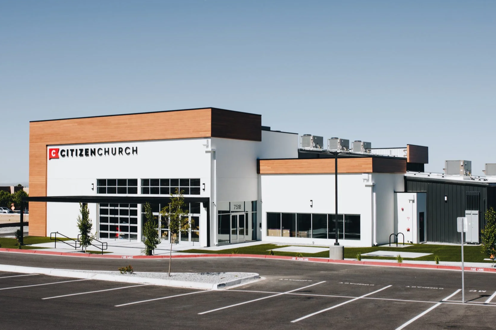 Exterior of a modern Citizen Church building with a parking lot in the foreground.