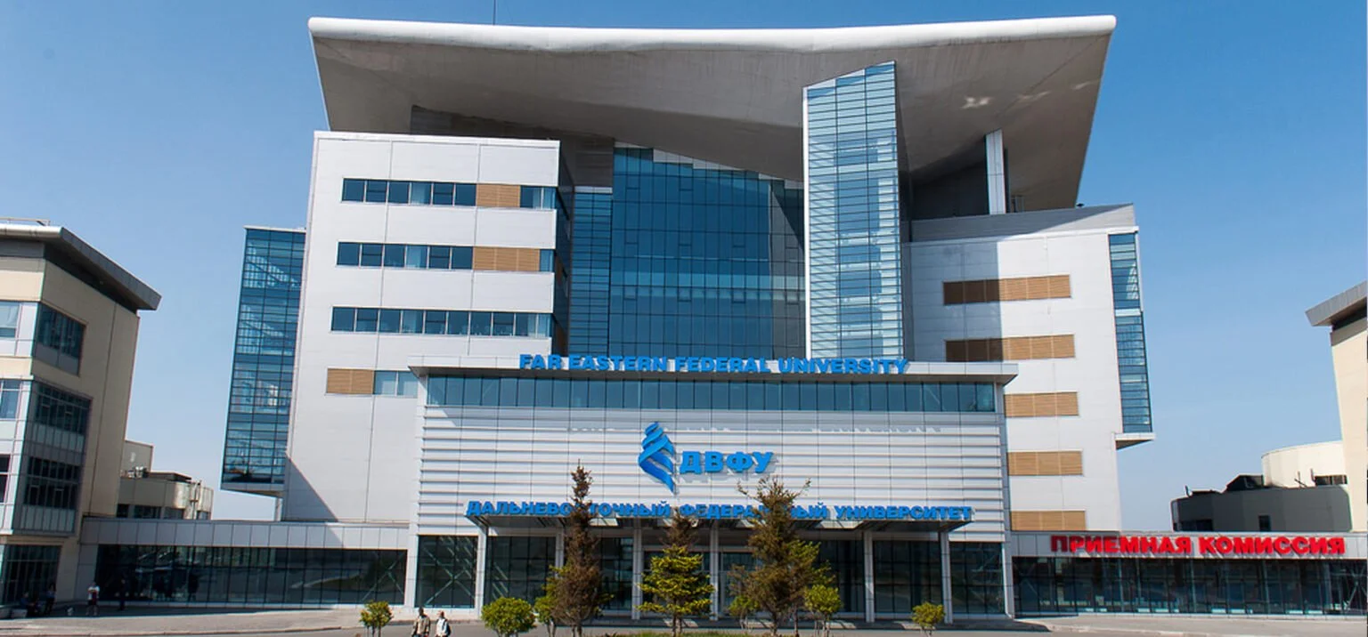 Modern university building with glass windows and a large overhanging roof. Signage indicates it is Far Eastern Federal University in both English and Russian.