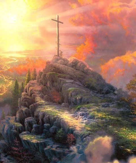 A wooden cross on a hilltop with clouds and colorful sky at sunset.