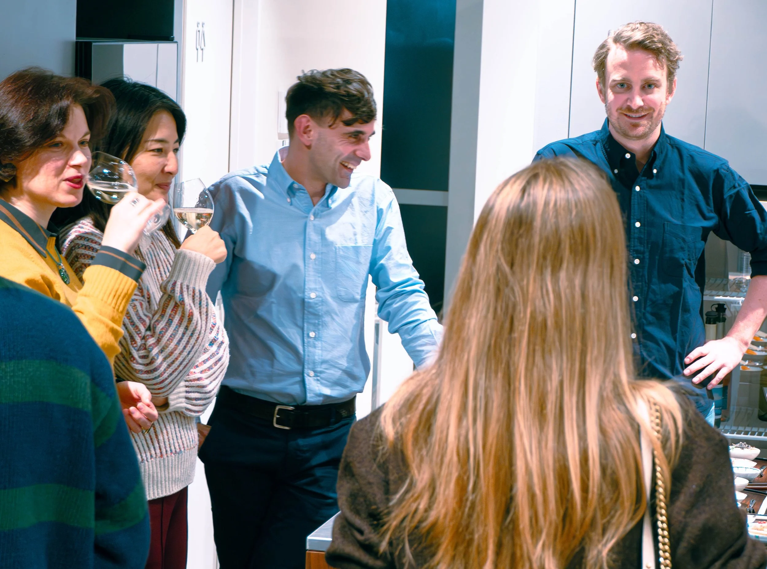 Guests chatting at the bar while ordering Japanese wine by the glass at THREE GRAPES, a boutique wine spot near Meiji Jingu in Tokyo.