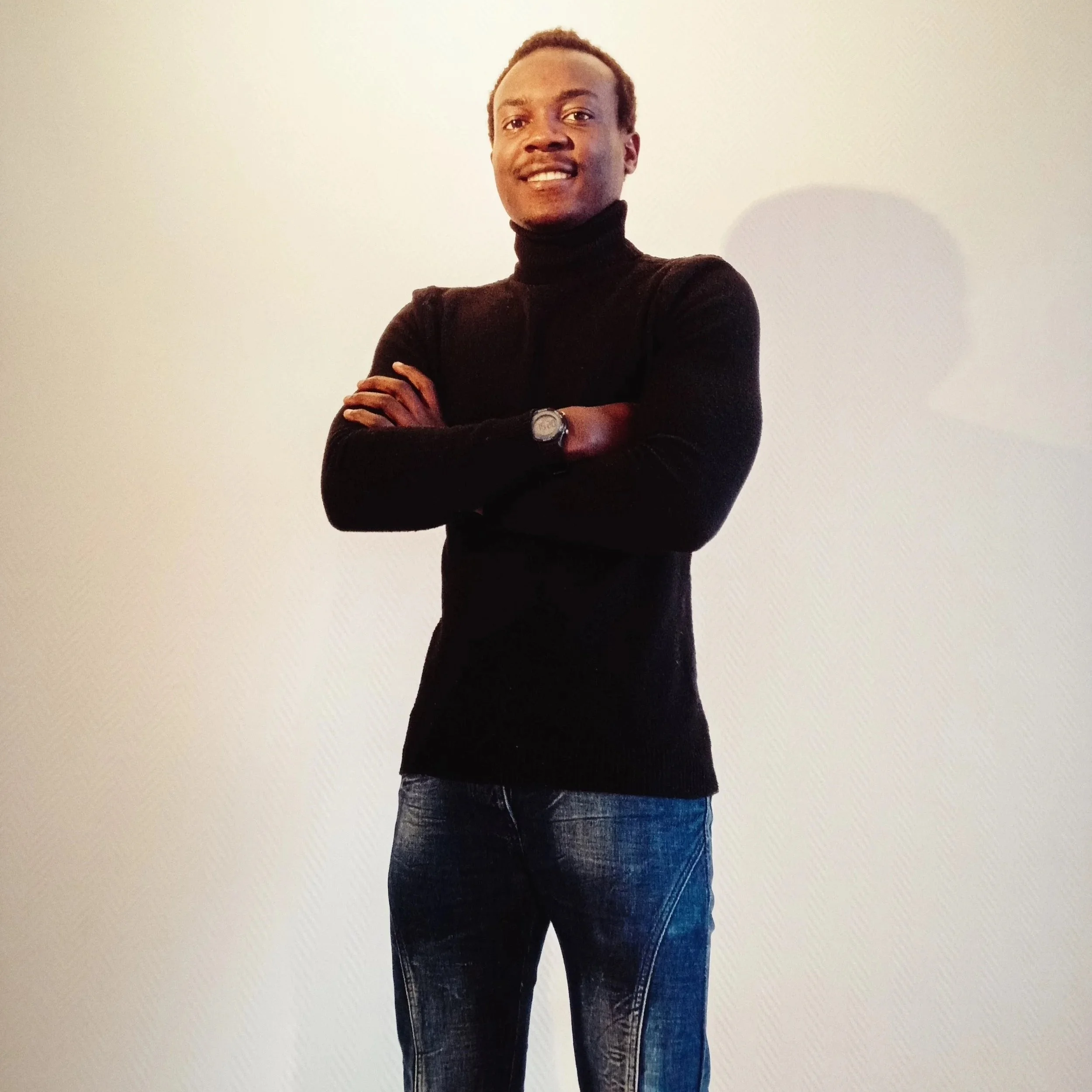 smiling man with crossed hands in a standing position