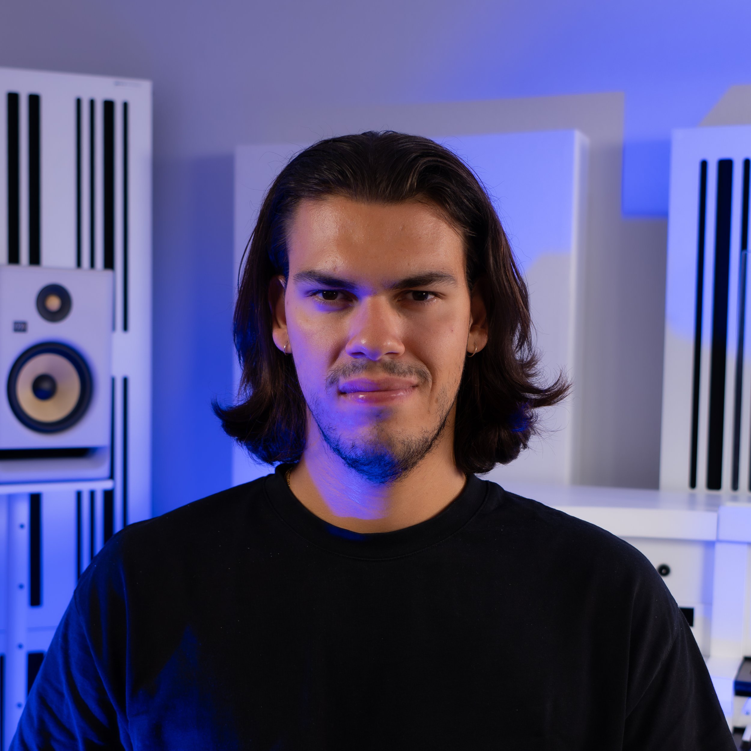 Giulio Lucciola, concert organist and church musician, portrayed in a modern recording studio with white acoustic panels and blue lighting.