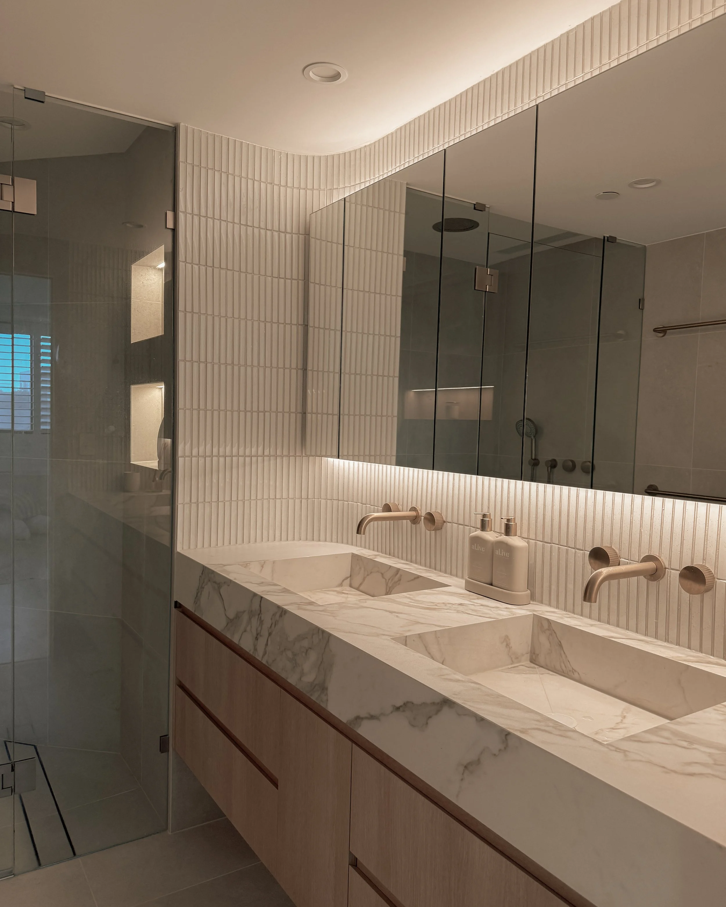 Modern bathroom with stone sink, double vanity, and warm timber tones — coastal apartment in Gold Coast designed by TID Studio Sydney