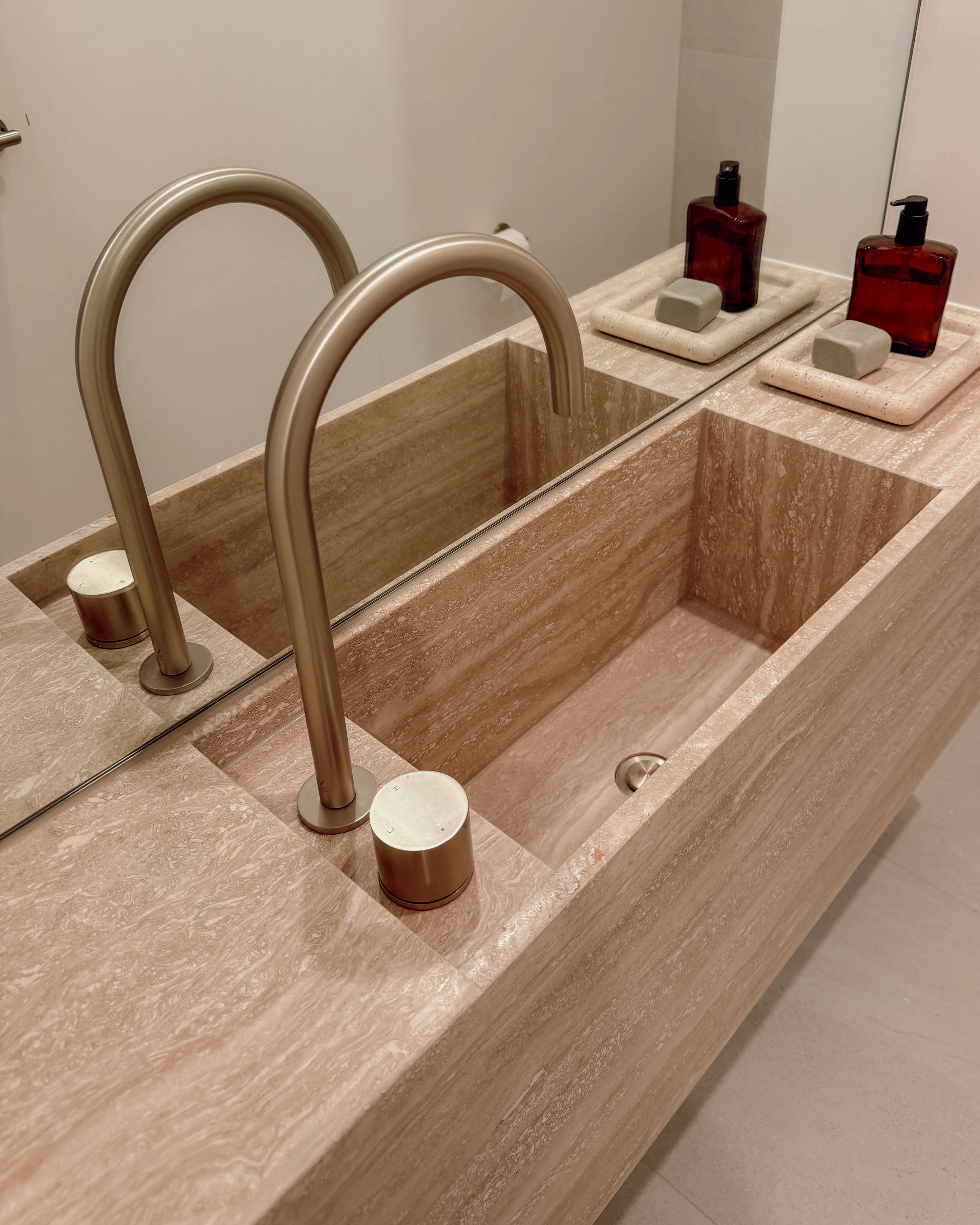 Contemporary powder room, modern bathroom design with custom stone sink, in travertine. New-build in Melbourne. TID Studio interior design in Sydney