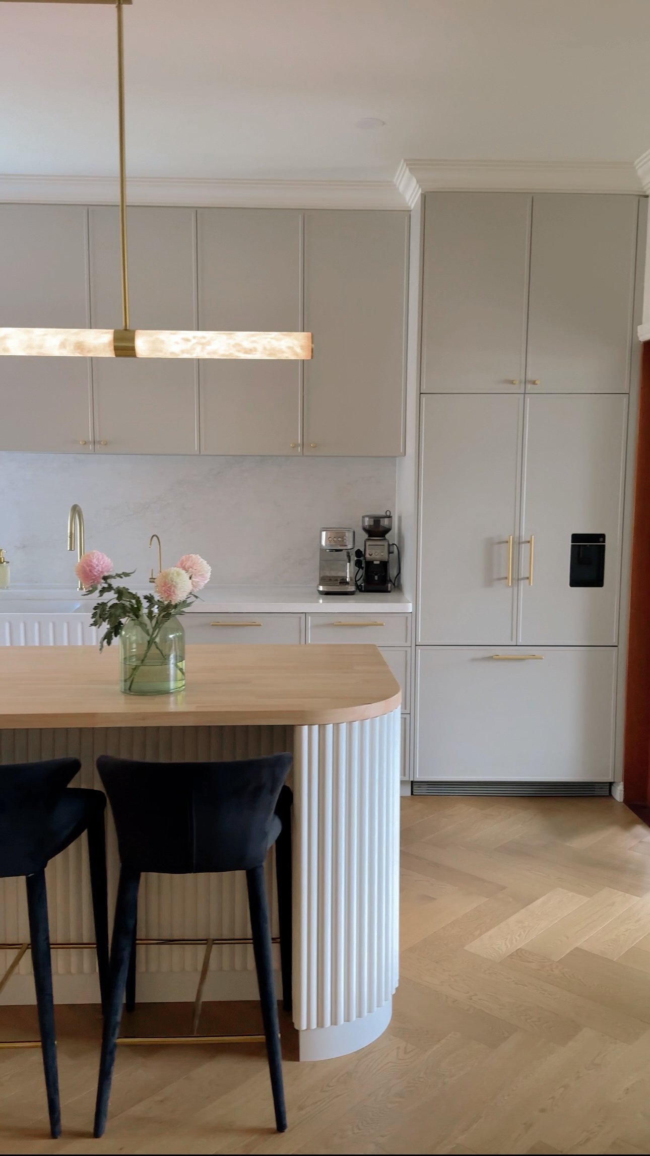 Modern Brisbane kitchen render showing curved island, warm timber tones and integrated appliances
