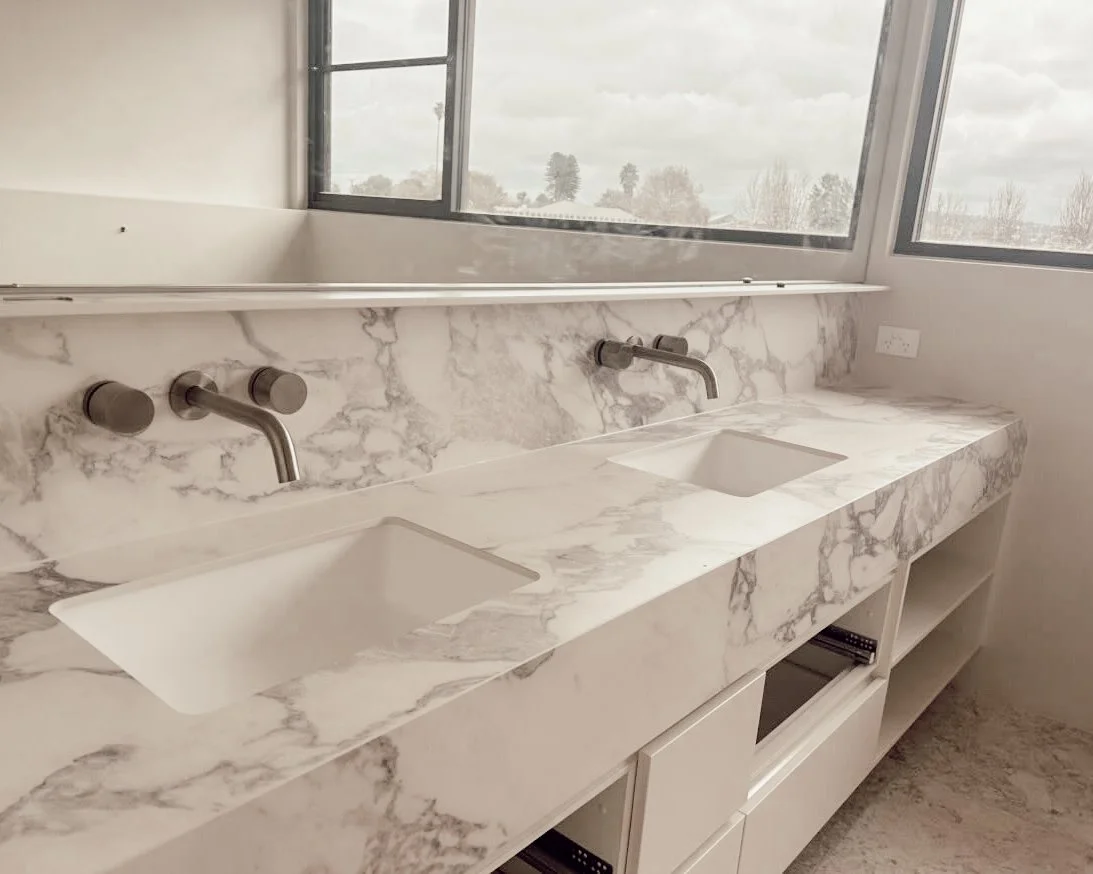 A serene, modern bathroom with marble surfaces and soft timber detailing, part of TID Studio’s Sydney renovation